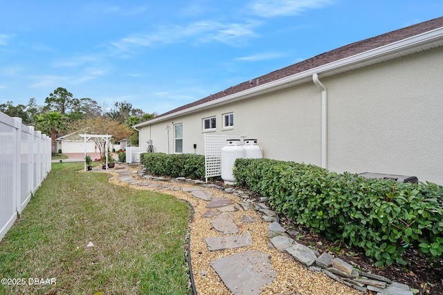 view of property exterior featuring a yard and a pergola