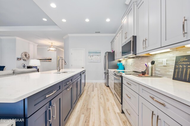 kitchen featuring sink, light hardwood / wood-style flooring, dishwasher, a tray ceiling, and an island with sink