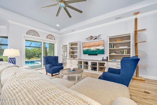 bedroom featuring access to outside, ceiling fan, light hardwood / wood-style floors, a raised ceiling, and crown molding