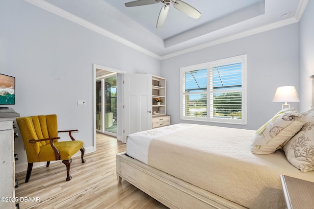 bedroom featuring a tray ceiling, ornamental molding, access to outside, light hardwood / wood-style floors, and ceiling fan