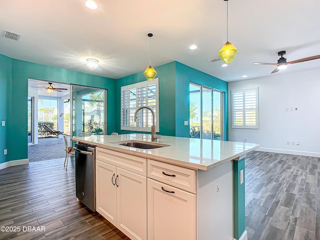 kitchen featuring a center island with sink, sink, hanging light fixtures, dark hardwood / wood-style floors, and white cabinetry