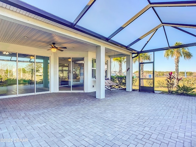 unfurnished sunroom featuring ceiling fan