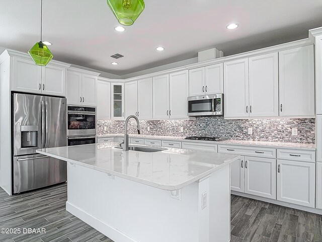 182 Island Breeze Ave, Daytona Beach, FL 32124 - kitchen with appliances with stainless steel finishes, a sink, white cabinetry, dark wood-style floors, and recessed lighting