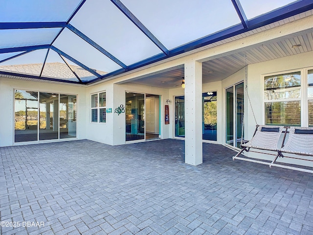 exterior space featuring glass enclosure and ceiling fan