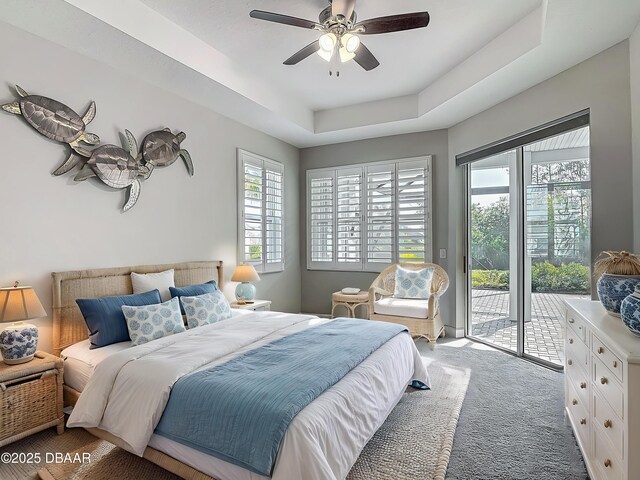 182 Island Breeze Ave, Daytona Beach, FL 32124 - carpeted bedroom featuring access to exterior, ceiling fan, and a tray ceiling