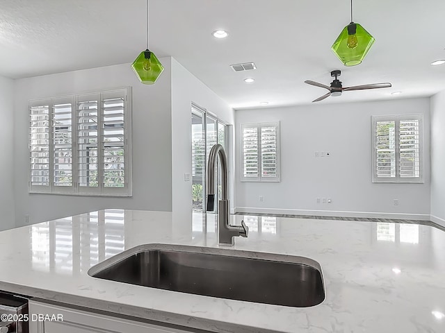 182 Island Breeze Ave, Daytona Beach, FL 32124 - kitchen view of a sink, ceiling fan, hanging light fixtures, recessed lighting, and light stone counters