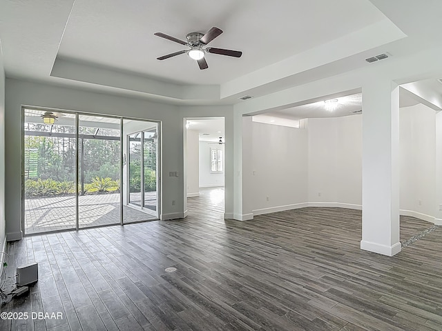 182 Island Breeze Ave, Daytona Beach, FL 32124 - unfurnished living room featuring a raised ceiling, ceiling fan, baseboards, and dark wood-style floors