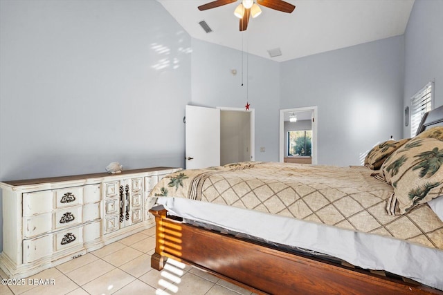 tiled bedroom featuring multiple windows, ceiling fan, and high vaulted ceiling