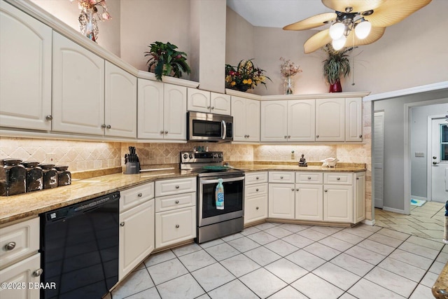 kitchen featuring decorative backsplash, appliances with stainless steel finishes, and a towering ceiling