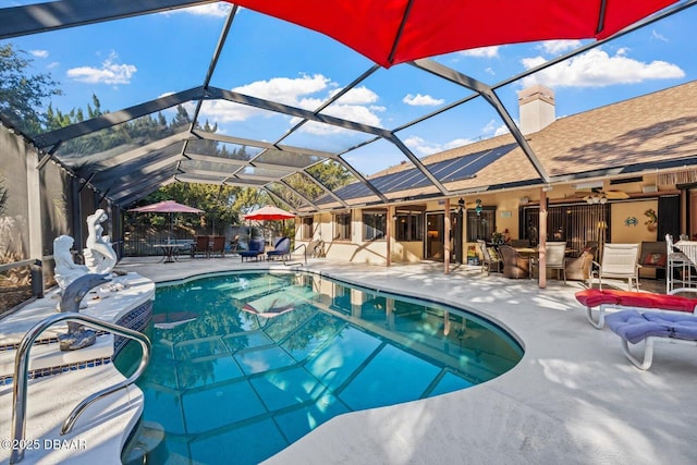 view of pool with glass enclosure, ceiling fan, and a patio area