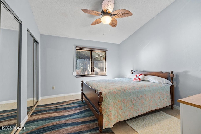 tiled bedroom featuring a textured ceiling, ceiling fan, and vaulted ceiling