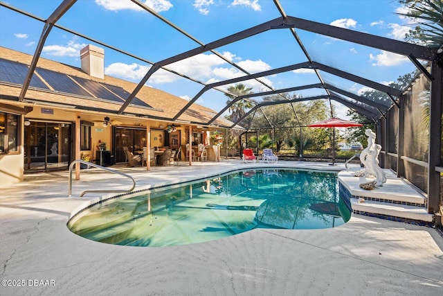 view of swimming pool with glass enclosure and a patio