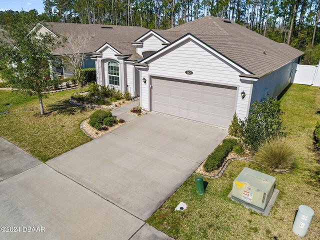 ranch-style house with a garage and a front lawn