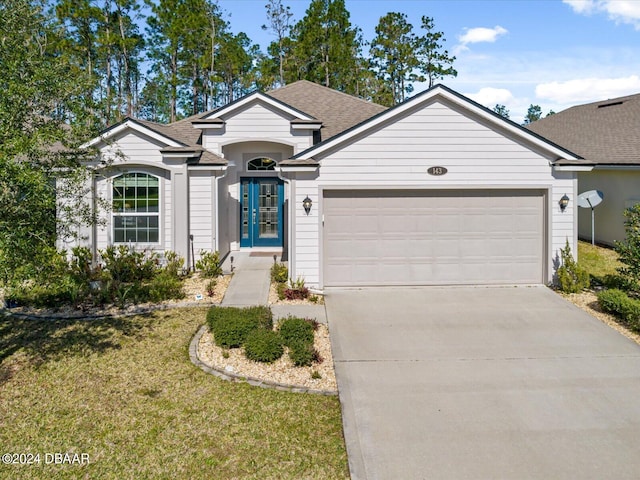 ranch-style home featuring a garage and a front lawn