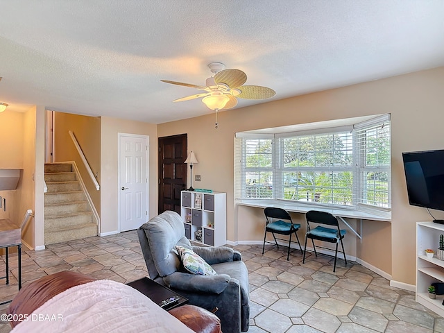 living room featuring stairway, a textured ceiling, a healthy amount of sunlight, and ceiling fan