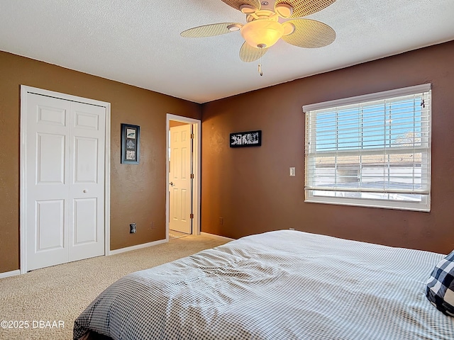 bedroom featuring a closet, carpet floors, a textured ceiling, and a ceiling fan