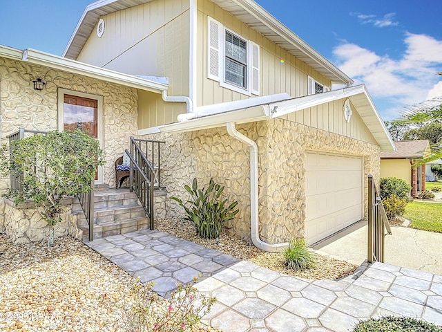 view of side of home with stone siding and an attached garage