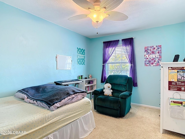 carpeted bedroom with ceiling fan, a textured ceiling, and baseboards