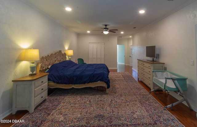 bedroom featuring crown molding, ceiling fan, a closet, and dark wood-type flooring