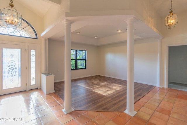 entryway with light hardwood / wood-style floors, a high ceiling, and a notable chandelier