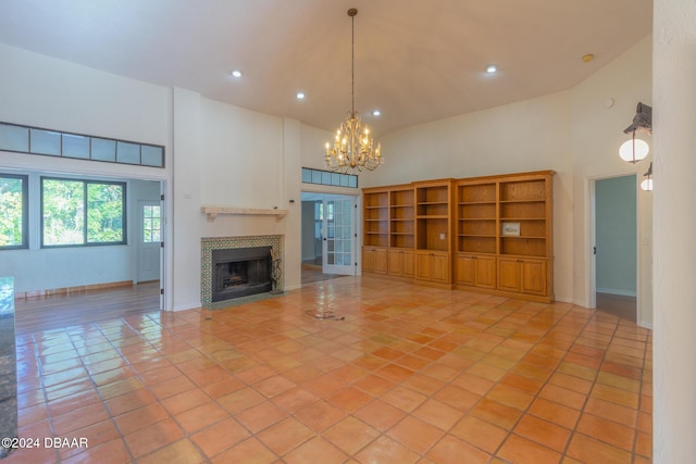 unfurnished living room featuring a tiled fireplace, high vaulted ceiling, and light tile patterned flooring