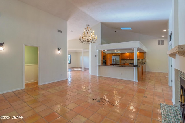 unfurnished living room featuring high vaulted ceiling, a chandelier, and light tile patterned floors