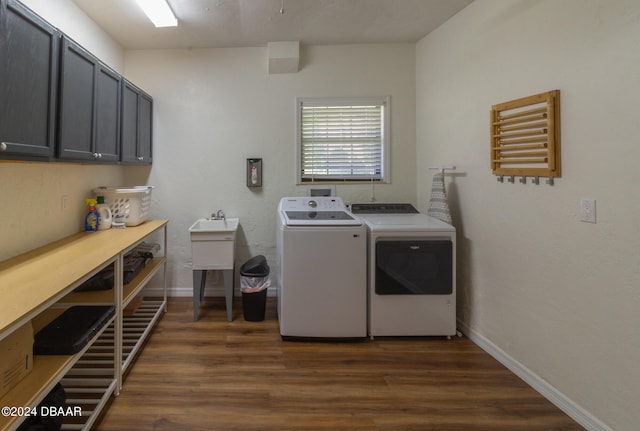 laundry area featuring washer and dryer, dark hardwood / wood-style flooring, and cabinets