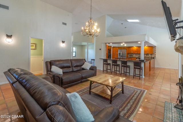 tiled living room featuring high vaulted ceiling and a chandelier