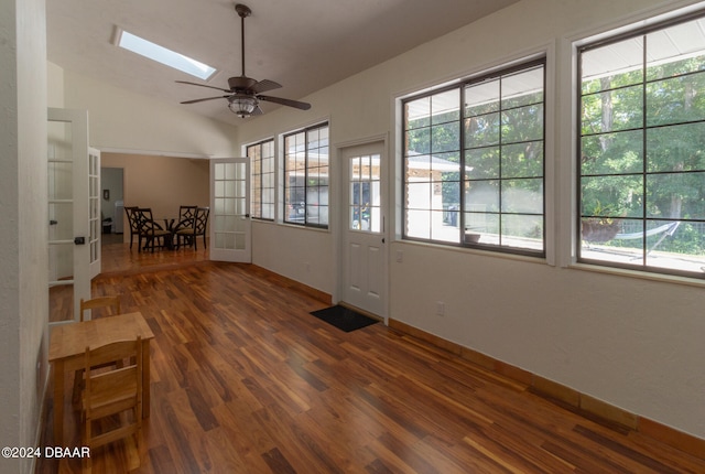 interior space featuring ceiling fan, dark hardwood / wood-style floors, and lofted ceiling with skylight