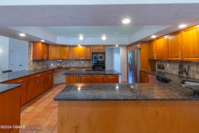 kitchen with a raised ceiling, hanging light fixtures, a center island, and black appliances