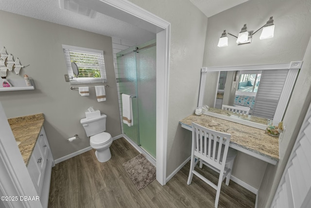 bathroom featuring wood-type flooring, a textured ceiling, toilet, and a shower with shower door