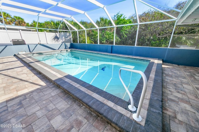 view of swimming pool featuring glass enclosure and a patio area