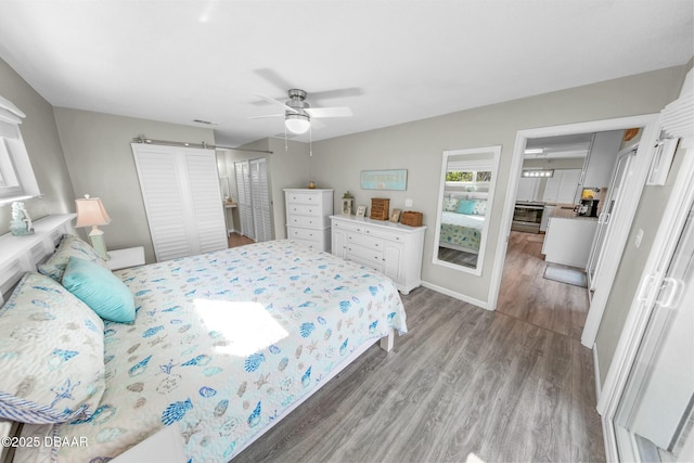 bedroom with a closet, light hardwood / wood-style floors, and ceiling fan