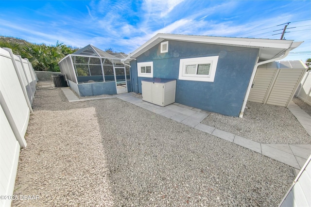 back of property with central AC and a lanai