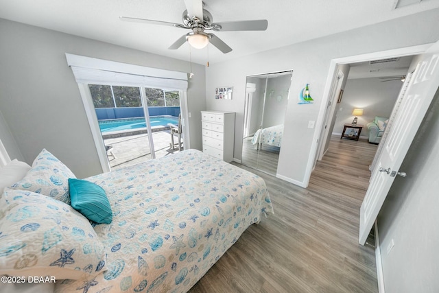 bedroom featuring access to exterior, light hardwood / wood-style floors, and ceiling fan