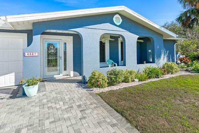 view of exterior entry featuring covered porch, a garage, and a yard