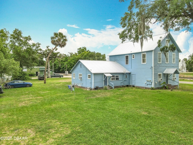 161 W 2nd Ave, Pierson, FL 32180 - rear view of property with entry steps, a metal roof, and a lawn