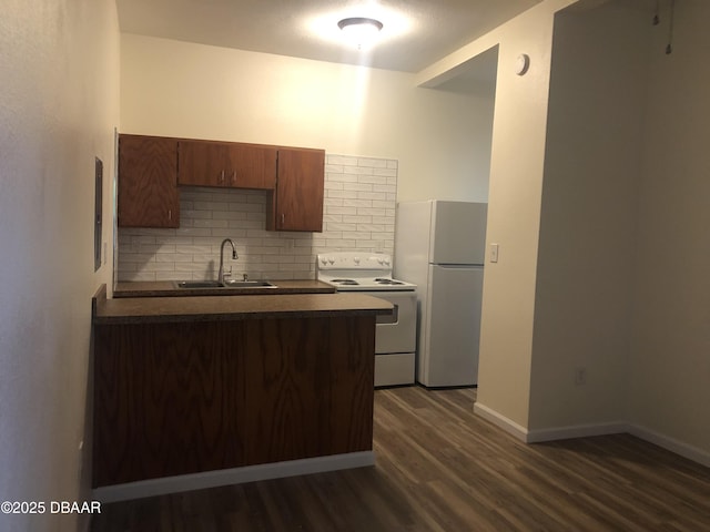 161 W 2nd Ave, Pierson, FL 32180 - kitchen featuring white appliances, dark countertops, tasteful backsplash, dark wood-style flooring, and a peninsula