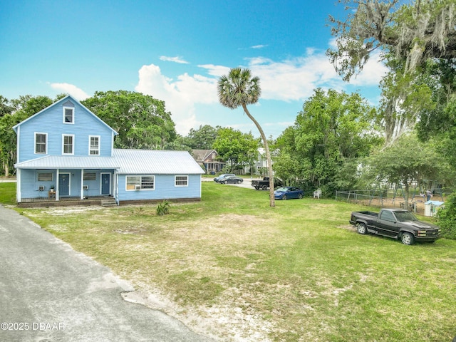 161 W 2nd Ave, Pierson, FL 32180 - view of front of house featuring covered porch, a metal roof, a front lawn, and view of scattered trees