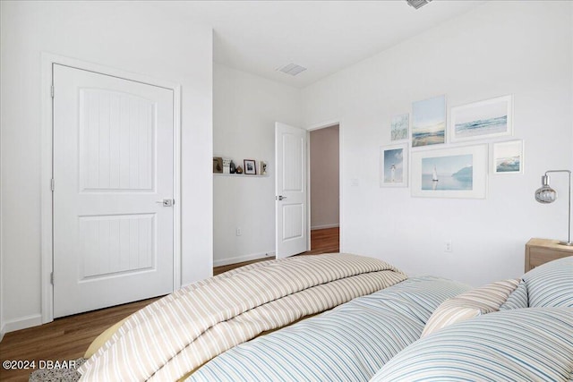 bedroom with dark hardwood / wood-style flooring