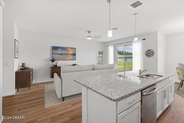 kitchen with a kitchen island with sink, sink, stainless steel dishwasher, and white cabinets