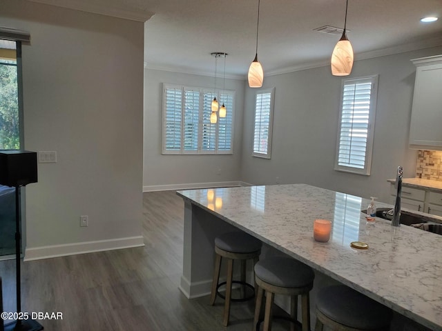 580 Barefoot Life Ln, Daytona Beach, FL 32124 - kitchen with visible vents, decorative light fixtures, light stone countertops, crown molding, and a sink