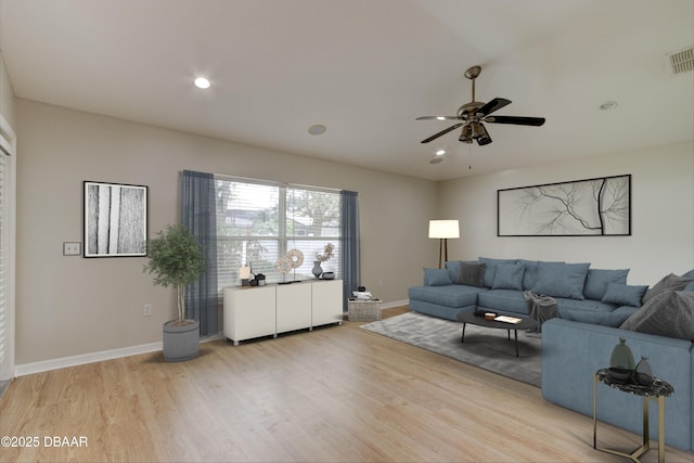 living room with light hardwood / wood-style floors and ceiling fan