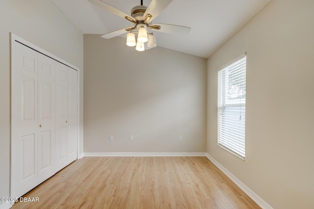 unfurnished bedroom featuring lofted ceiling, ceiling fan, a closet, and light hardwood / wood-style flooring