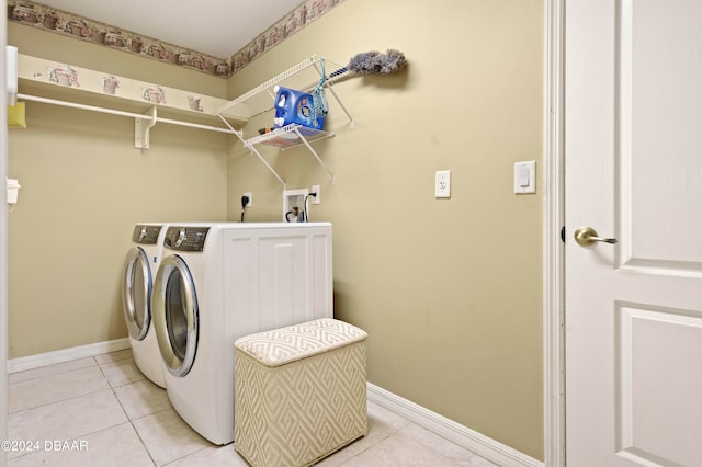 laundry area with light tile patterned floors and washer and clothes dryer