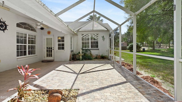 unfurnished sunroom featuring ceiling fan and a skylight