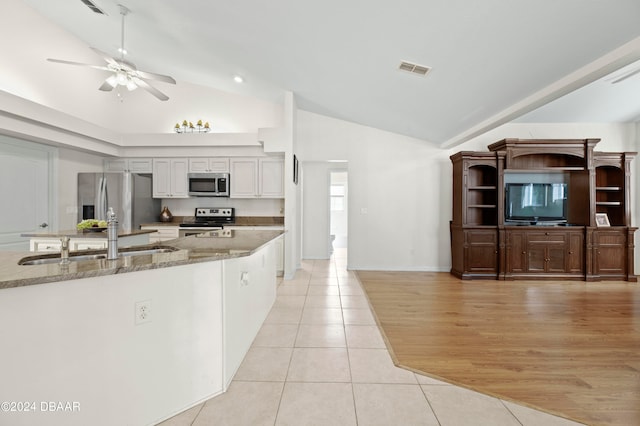 kitchen featuring light stone counters, light tile patterned flooring, stainless steel appliances, white cabinets, and ceiling fan