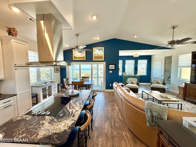 2948 N Ocean Shore Blvd, Flagler Beach, FL 32136 - interior space with white cabinets, a ceiling fan, open floor plan, wood finished floors, and lofted ceiling