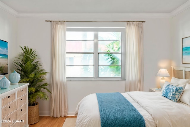 bedroom featuring ornamental molding and light wood-type flooring