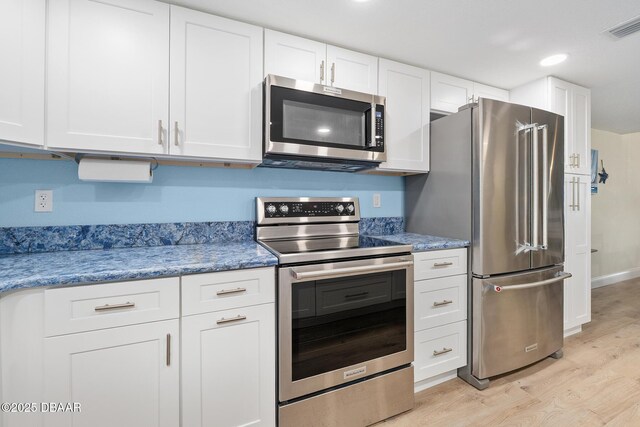 3807 S Atlantic Ave Unit 203, Daytona Beach, FL 32118 - kitchen featuring stainless steel appliances, light wood finished floors, white cabinets, recessed lighting, and stone countertops